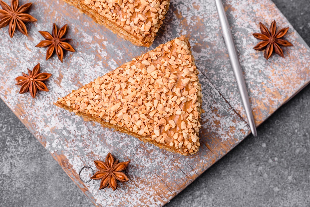 Delicioso bolo de waffle doce com creme e nozes cortados em pedaços sobre um fundo de concreto texturizado