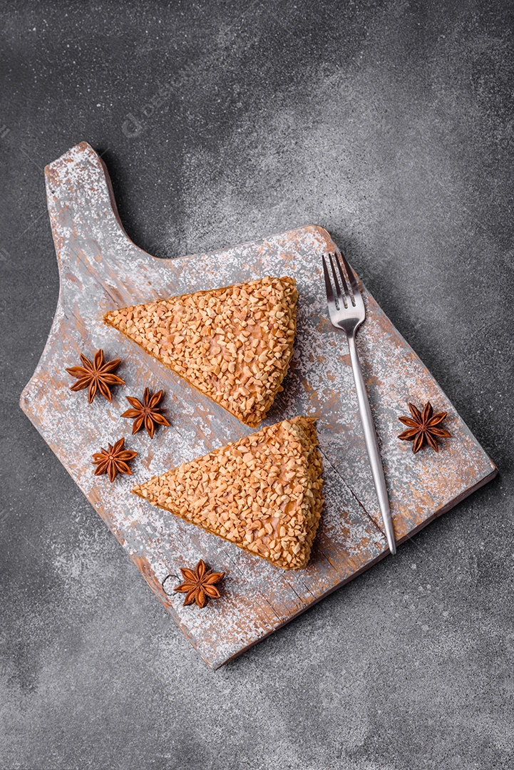 Delicioso bolo de waffle doce com creme e nozes cortados em pedaços sobre um fundo de concreto texturizado