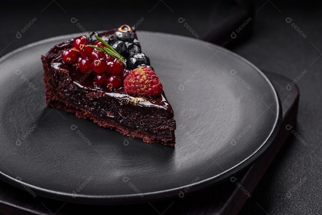 Delicioso bolo de brownie de chocolate doce com mirtilos, groselhas e framboesas num prato de cerâmica