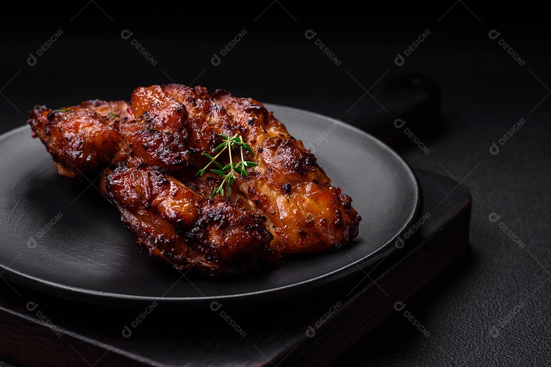 Deliciosa carne de frango assada com sal, especiarias e ervas sobre um fundo escuro de concreto