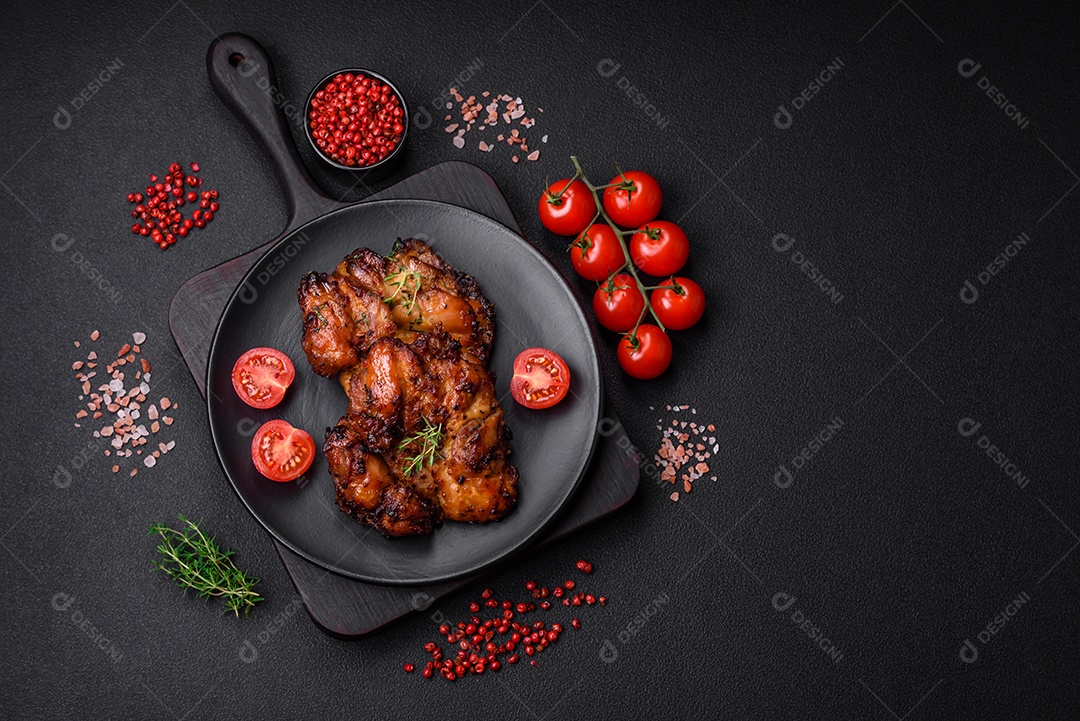 Deliciosa carne de frango assada com sal, especiarias e ervas sobre um fundo escuro de concreto