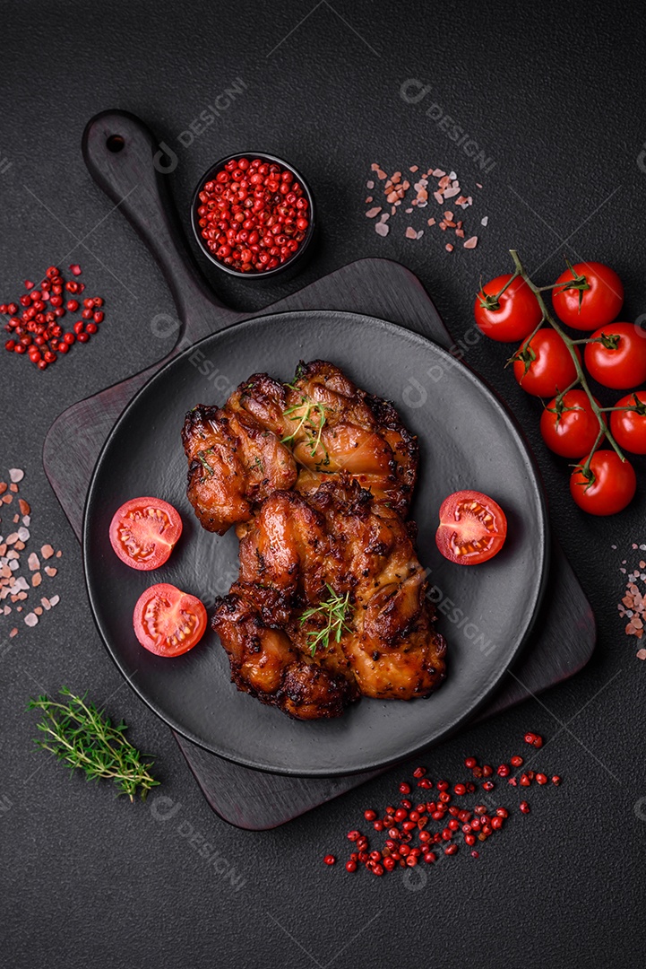 Deliciosa carne de frango assada com sal, especiarias e ervas sobre um fundo escuro de concreto