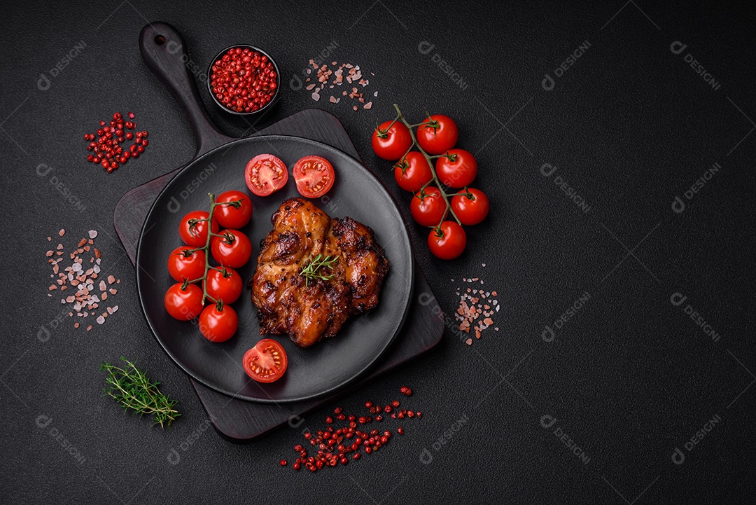 Deliciosa carne de frango assada com sal, especiarias e ervas sobre um fundo escuro de concreto