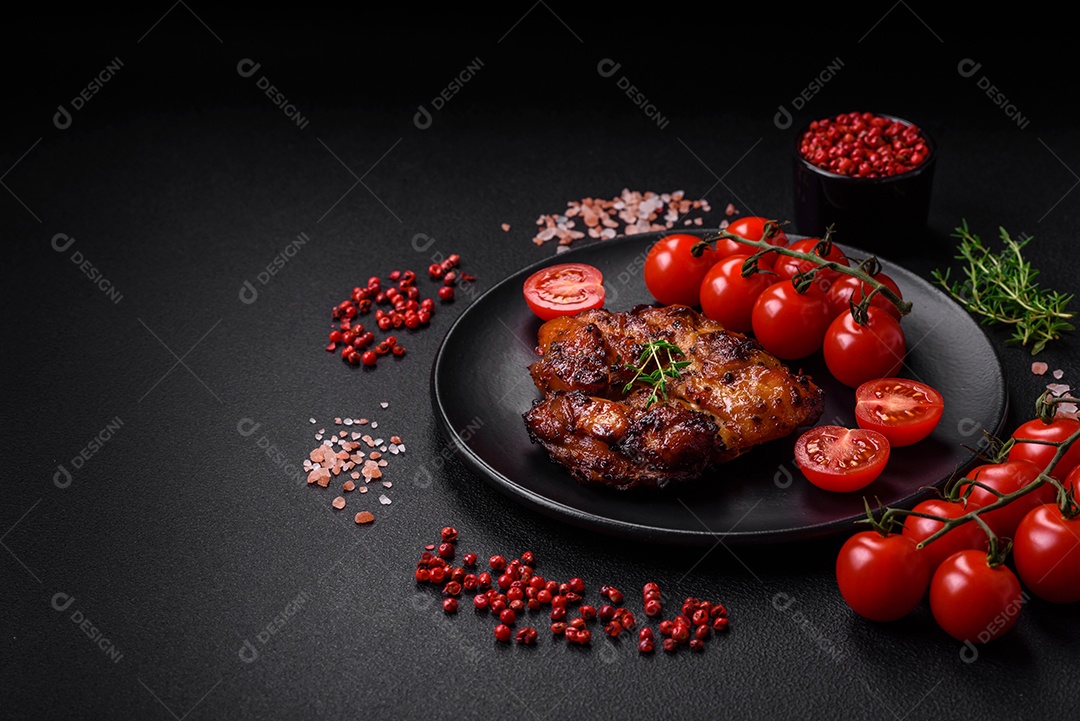 Deliciosa carne de frango assada com sal, especiarias e ervas sobre um fundo escuro de concreto