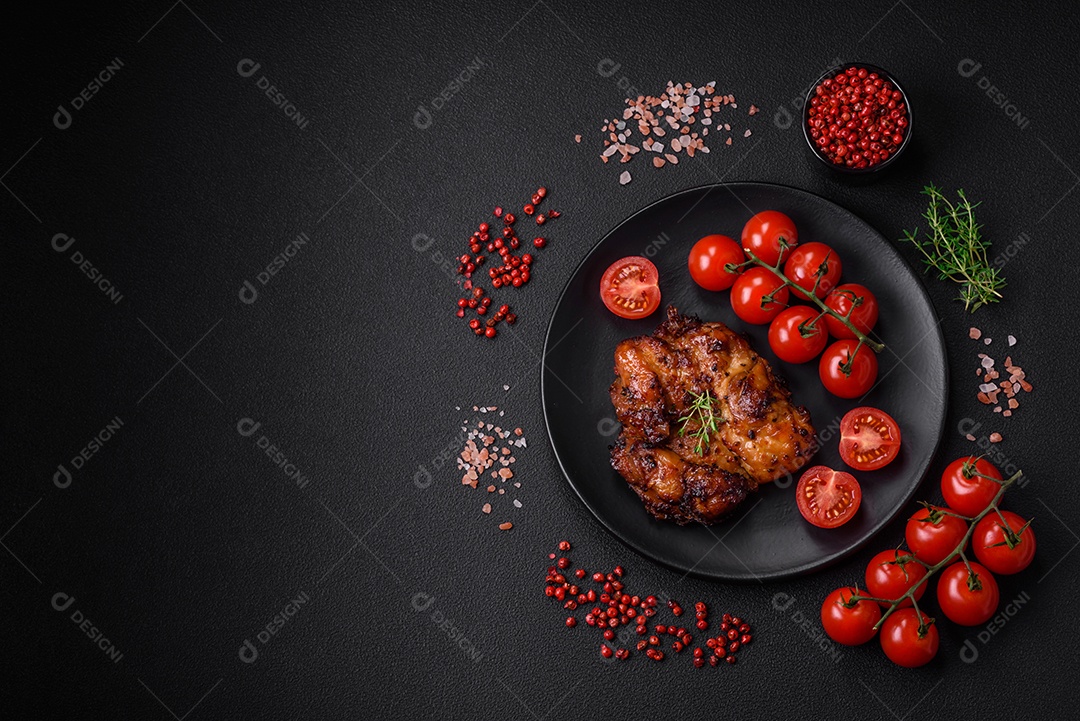 Deliciosa carne de frango assada com sal, especiarias e ervas sobre um fundo escuro de concreto