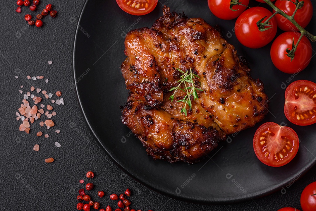 Deliciosa carne de frango assada com sal, especiarias e ervas sobre um fundo escuro de concreto