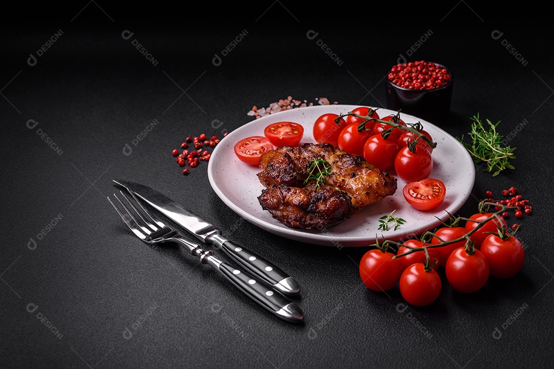 Deliciosa carne de frango assada com sal, especiarias e ervas sobre um fundo escuro de concreto