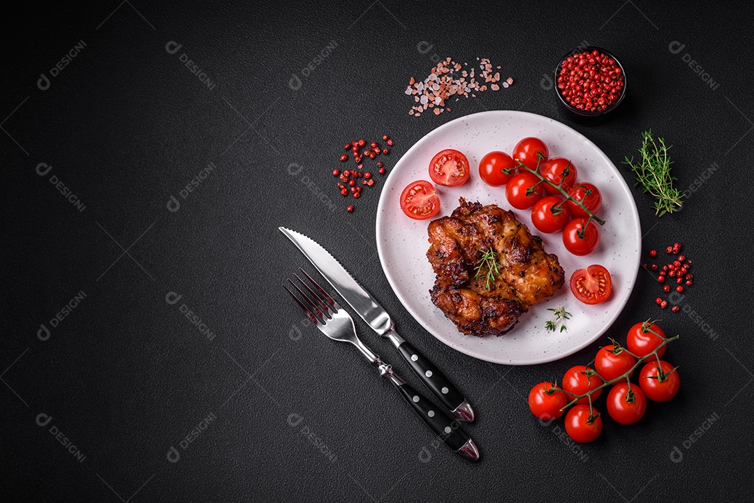 Deliciosa carne de frango assada com sal, especiarias e ervas sobre um fundo escuro de concreto