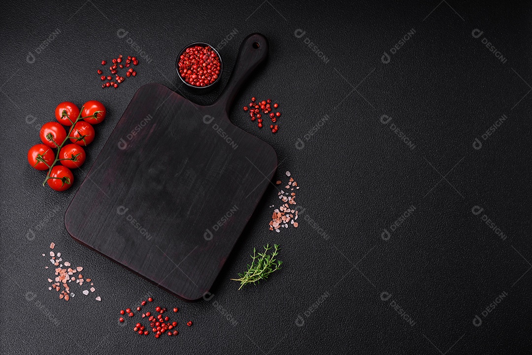 Deliciosos tomates cereja frescos nos galhos como ingrediente para cozinhar um prato vegetariano sobre um fundo escuro de concreto