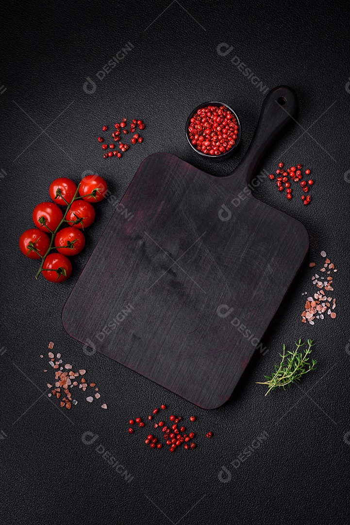 Deliciosos tomates cereja frescos nos galhos como ingrediente para cozinhar um prato vegetariano sobre um fundo escuro de concreto