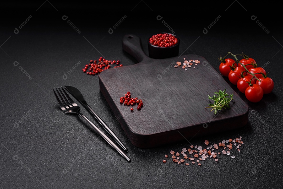 Deliciosos tomates cereja frescos nos galhos como ingrediente para cozinhar um prato vegetariano sobre um fundo escuro de concreto