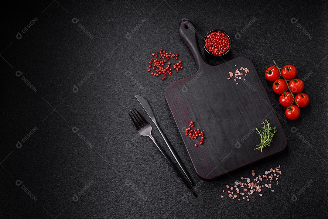 Deliciosos tomates cereja frescos nos galhos como ingrediente para cozinhar um prato vegetariano sobre um fundo escuro de concreto