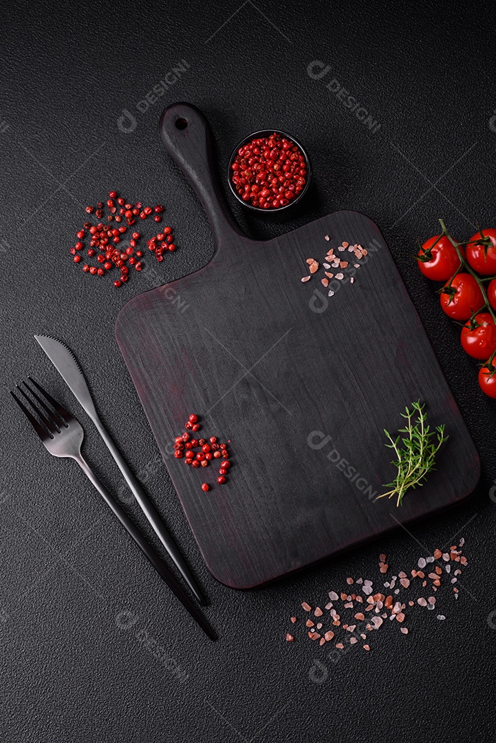 Deliciosos tomates cereja frescos nos galhos como ingrediente para cozinhar um prato vegetariano sobre um fundo escuro de concreto