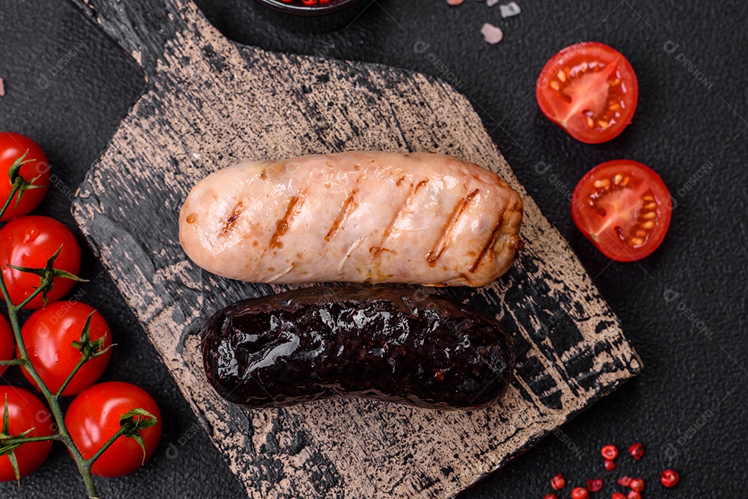 Deliciosas salsichas suculentas de diversas variedades grelhadas com sal, especiarias e ervas sobre um fundo escuro de concreto