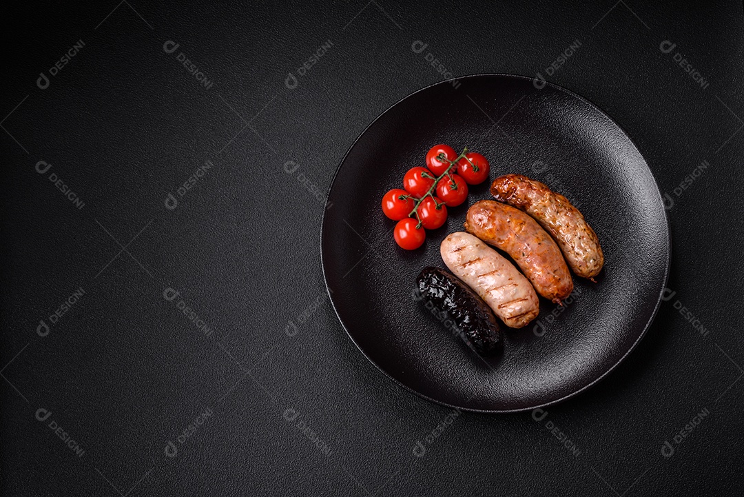 Deliciosas salsichas suculentas de diversas variedades grelhadas com sal, especiarias e ervas sobre um fundo escuro de concreto