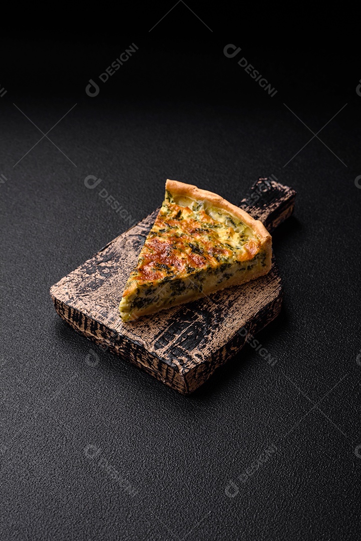 Deliciosa quiche fresca com brócolis, queijo, especiarias e ervas cortadas em pedaços sobre um fundo escuro de concreto