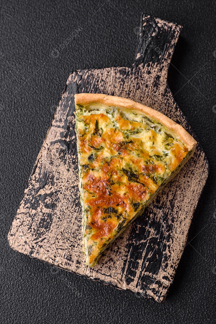 Deliciosa quiche fresca com brócolis, queijo, especiarias e ervas cortadas em pedaços sobre um fundo escuro de concreto