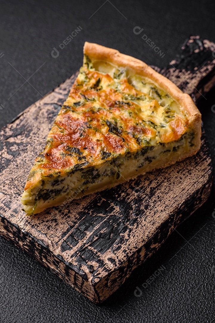 Deliciosa quiche fresca com brócolis, queijo, especiarias e ervas cortadas em pedaços sobre um fundo escuro de concreto