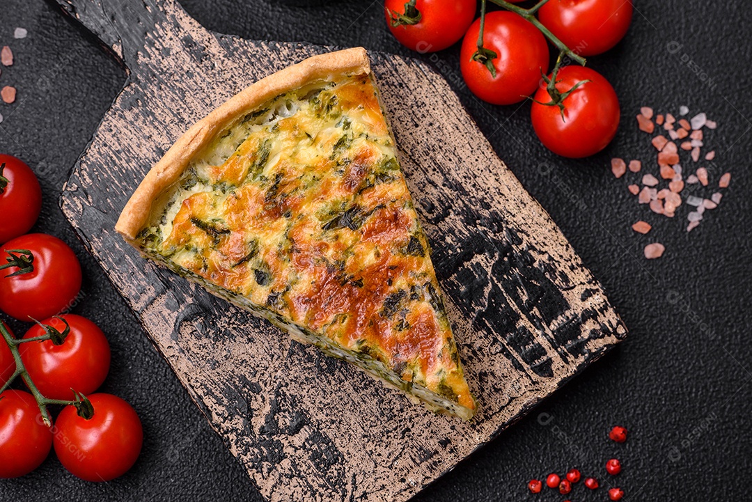 Deliciosa quiche fresca com brócolis, queijo, especiarias e ervas cortadas em pedaços sobre um fundo escuro de concreto