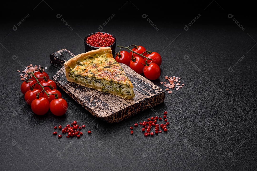 Deliciosa quiche fresca com brócolis, queijo, especiarias e ervas cortadas em pedaços sobre um fundo escuro de concreto