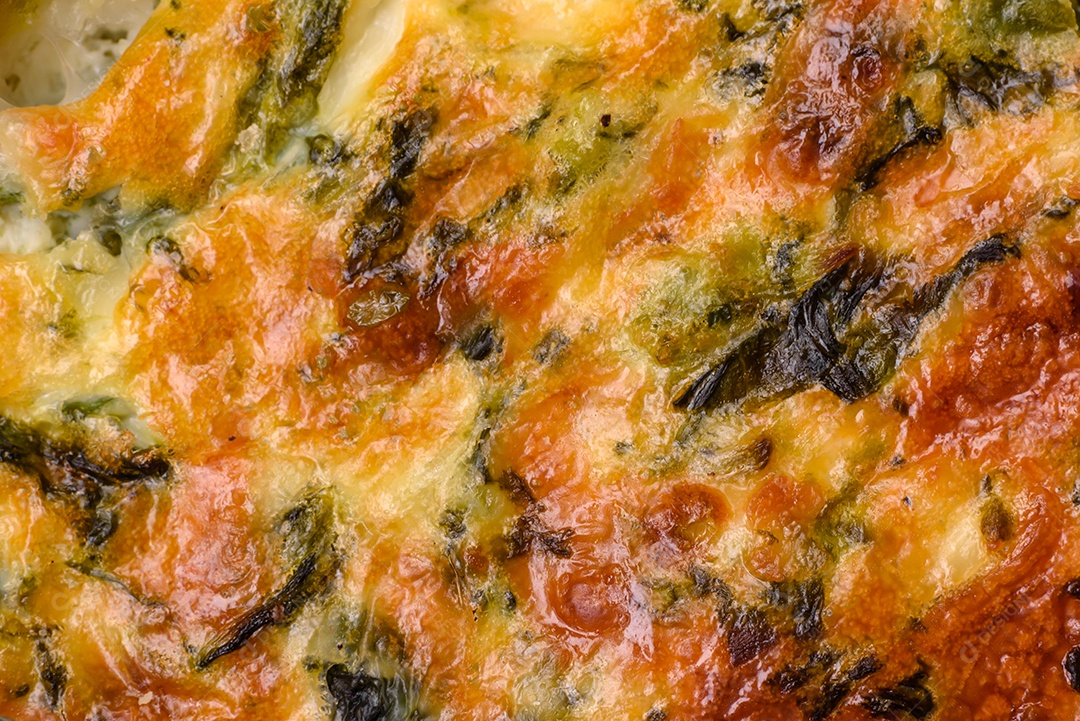 Deliciosa quiche fresca com brócolis, queijo, especiarias e ervas cortadas em pedaços sobre um fundo escuro de concreto