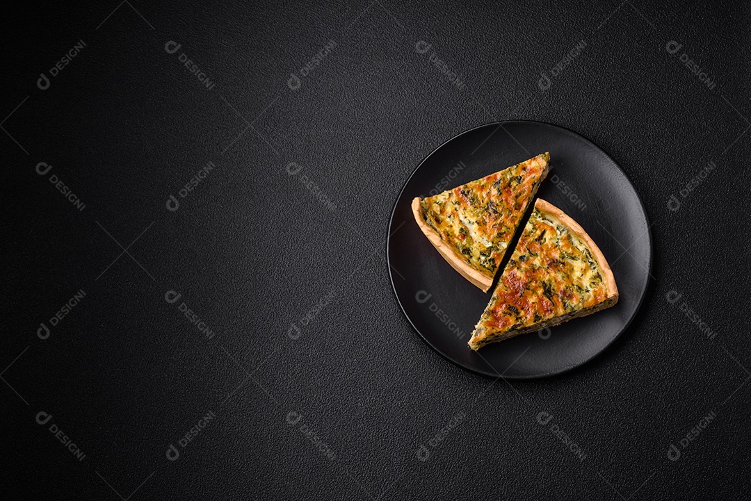 Deliciosa quiche fresca com brócolis, queijo, especiarias e ervas cortadas em pedaços sobre um fundo escuro de concreto