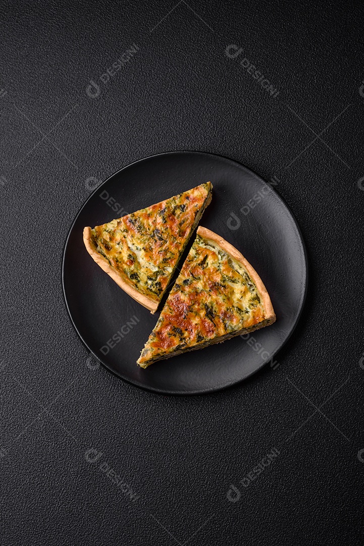 Deliciosa quiche fresca com brócolis, queijo, especiarias e ervas cortadas em pedaços sobre um fundo escuro de concreto