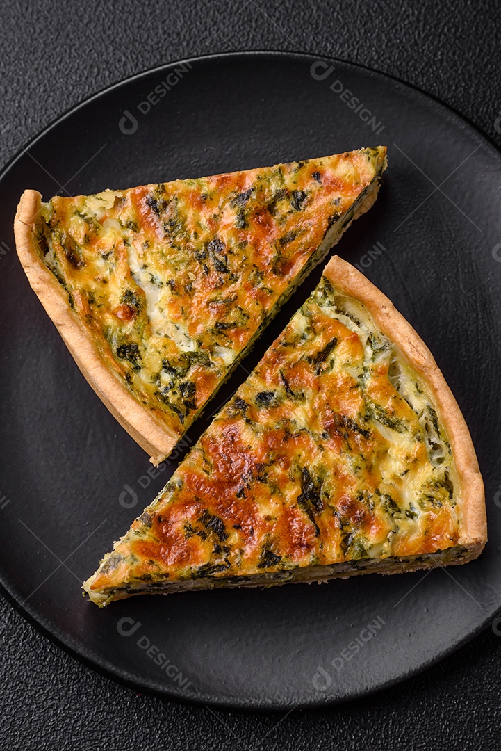 Deliciosa quiche fresca com brócolis, queijo, especiarias e ervas cortadas em pedaços sobre um fundo escuro de concreto