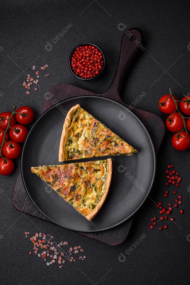 Deliciosa quiche fresca com brócolis, queijo, especiarias e ervas cortadas em pedaços sobre um fundo escuro de concreto