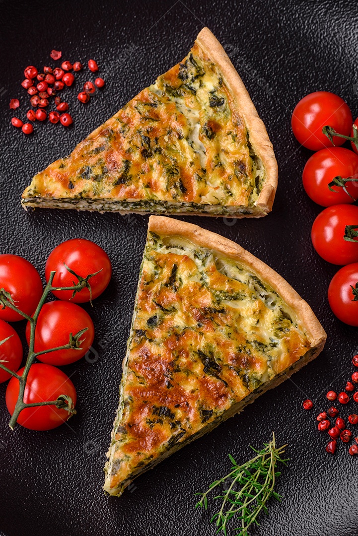 Deliciosa quiche fresca com brócolis, queijo, especiarias e ervas cortadas em pedaços sobre um fundo escuro de concreto