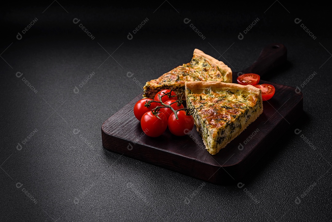 Deliciosa quiche fresca com brócolis, queijo, especiarias e ervas cortadas em pedaços sobre um fundo escuro de concreto
