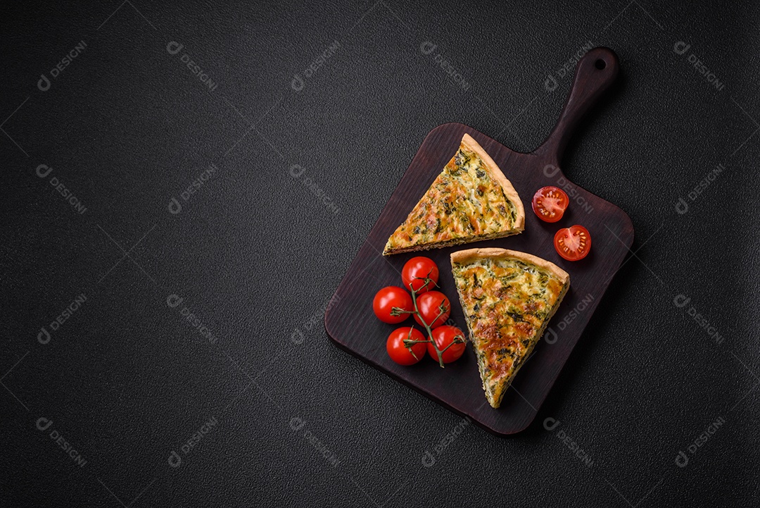 Deliciosa quiche fresca com brócolis, queijo, especiarias e ervas cortadas em pedaços sobre um fundo escuro de concreto