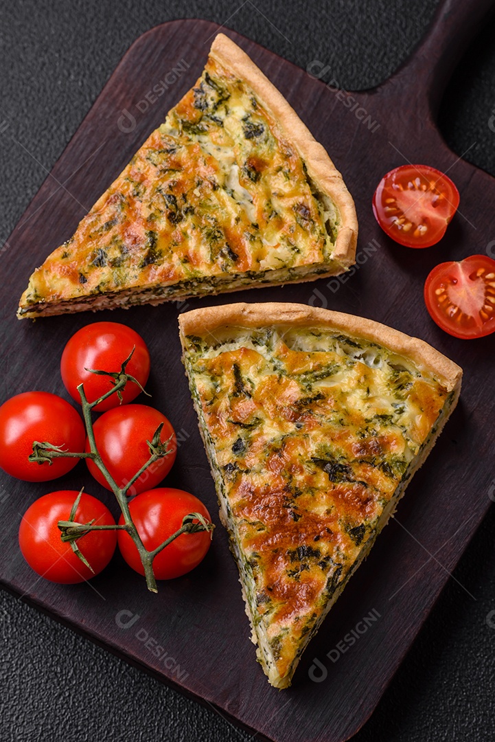 Deliciosa quiche fresca com brócolis, queijo, especiarias e ervas cortadas em pedaços sobre um fundo escuro de concreto