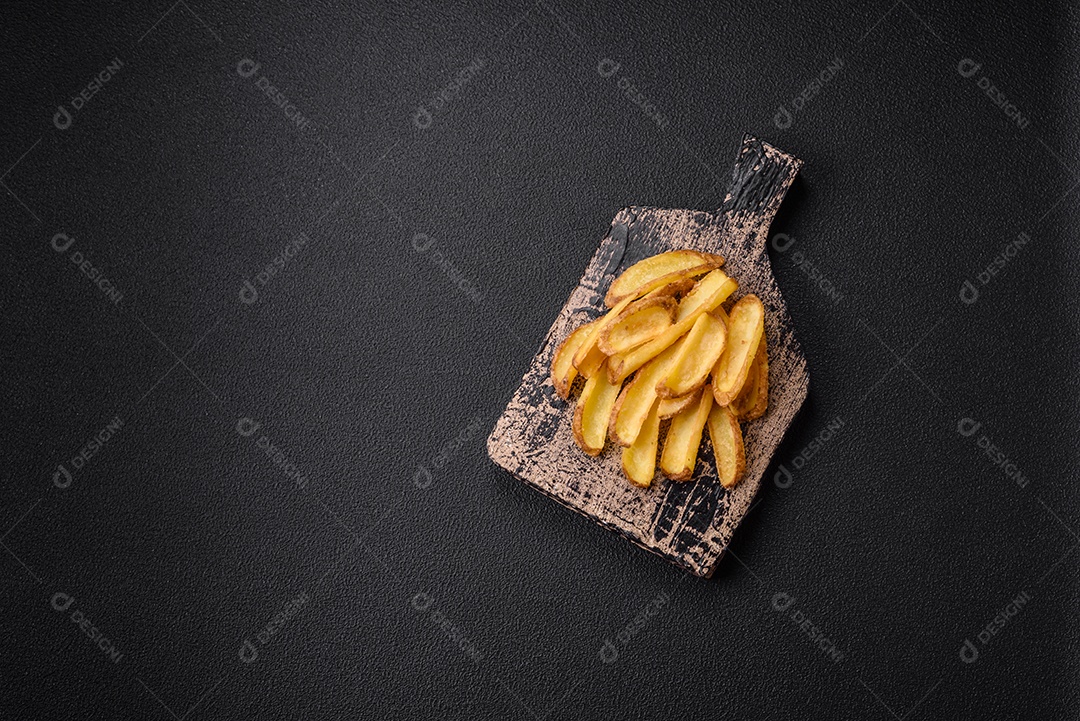 Deliciosas batatas crocantes com sal e especiarias em um fundo de concreto texturizado. Comida rápida