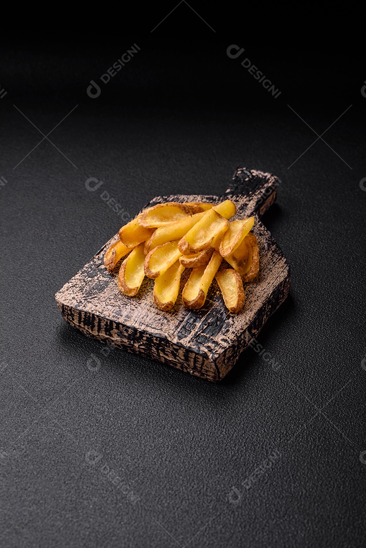 Deliciosas batatas crocantes com sal e especiarias em um fundo de concreto texturizado. Comida rápida