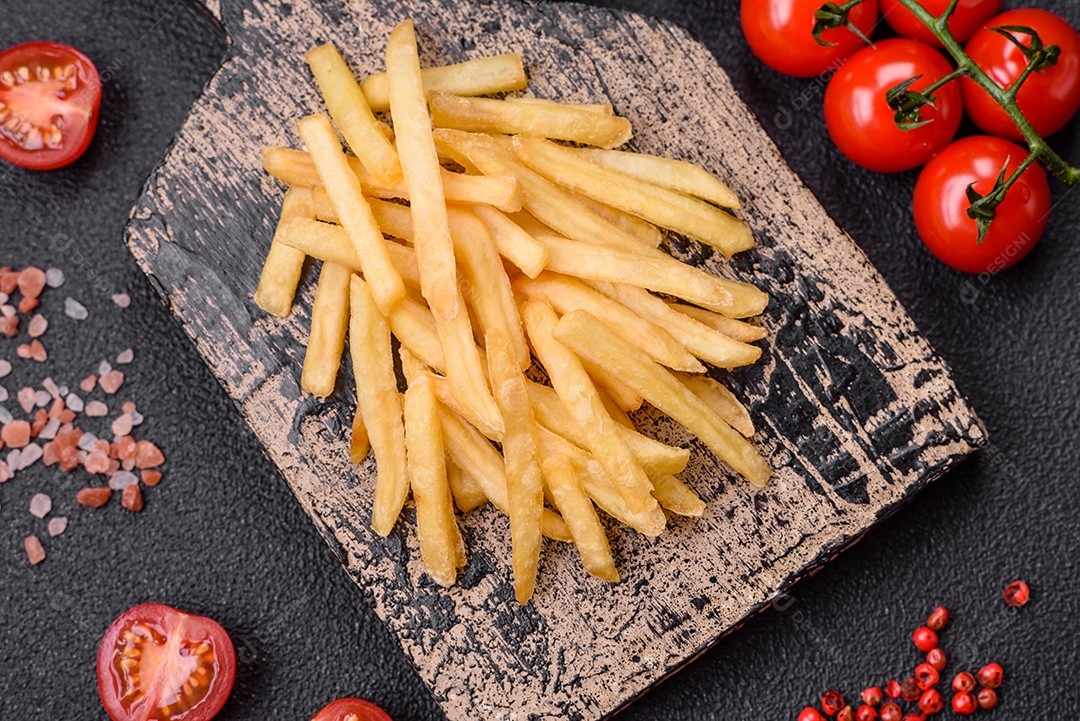 Deliciosas batatas crocantes com sal e especiarias em um fundo de concreto texturizado. Comida rápida