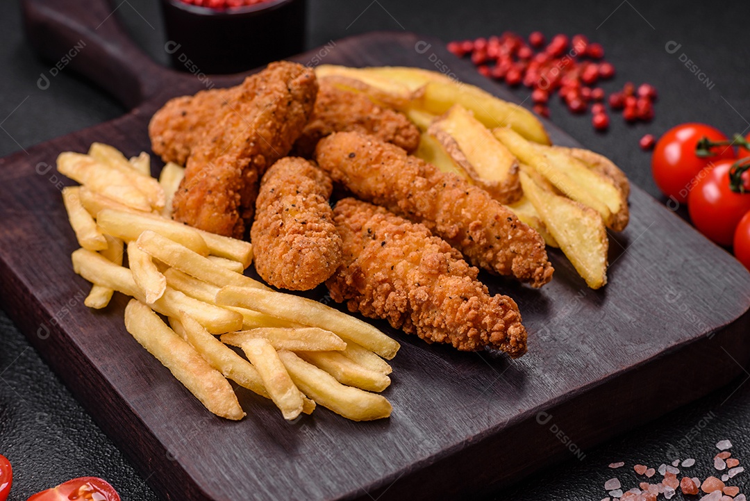 Deliciosos nuggets de frango crocantes à milanesa com sal e especiarias sobre um fundo escuro de concreto