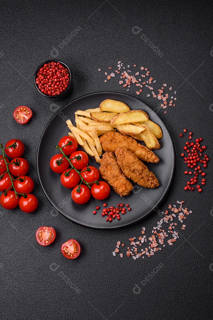 Deliciosos nuggets de frango crocantes à milanesa com sal e especiarias sobre um fundo escuro de concreto