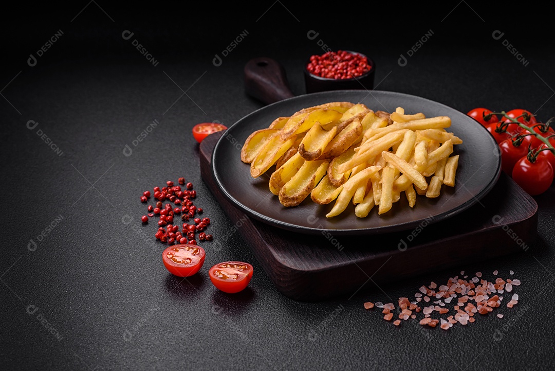 Deliciosas batatas fritas crocantes com sal e especiarias em um fundo de concreto texturizado. Comida rápida