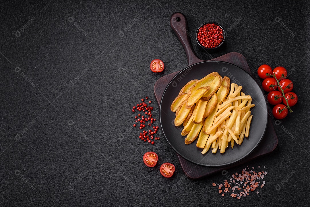 Deliciosas batatas fritas crocantes com sal e especiarias em um fundo de concreto texturizado. Comida rápida