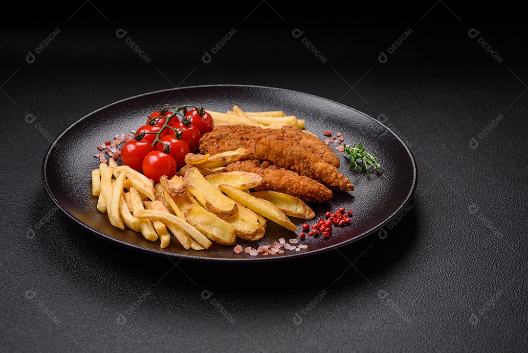 Deliciosos nuggets de frango crocantes à milanesa com sal e especiarias sobre um fundo escuro de concreto