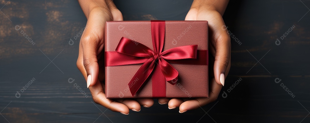 Mãos segurando uma linda caixa de presente vermelha