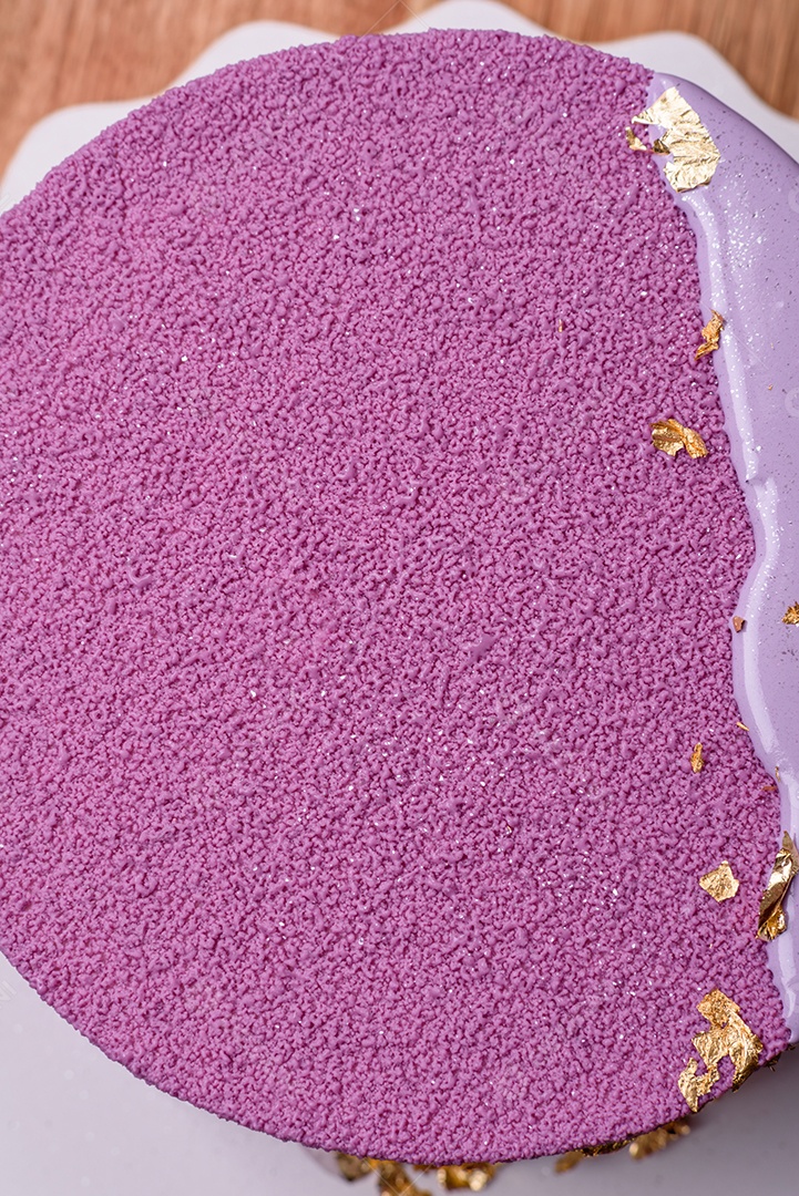 Delicioso bolo de mousse doce fresco com recheio de frutas vermelhas coberto com cobertura de veludo rosa sobre fundo escuro de concreto