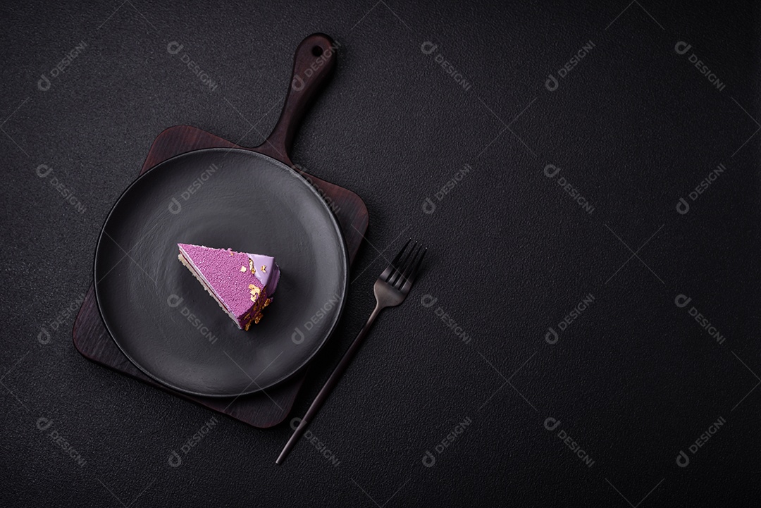 Delicioso bolo de mousse doce fresco com recheio de frutas vermelhas coberto com cobertura de veludo rosa sobre fundo escuro de concreto