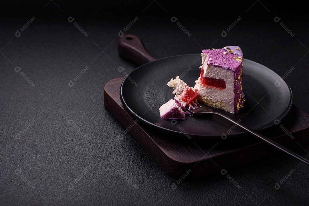 Delicioso bolo de mousse doce fresco com recheio de frutas vermelhas coberto com cobertura de veludo rosa sobre fundo escuro de concreto