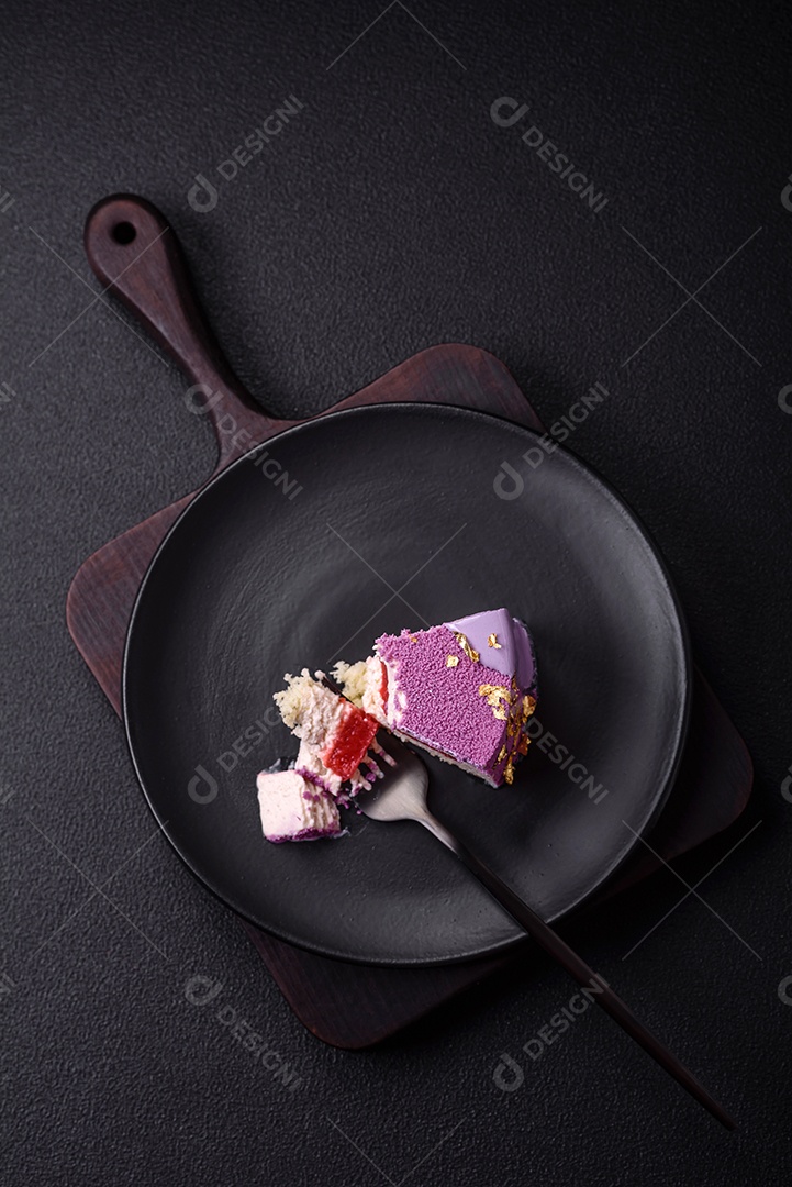 Delicioso bolo de mousse doce fresco com recheio de frutas vermelhas coberto com cobertura de veludo rosa sobre fundo escuro de concreto