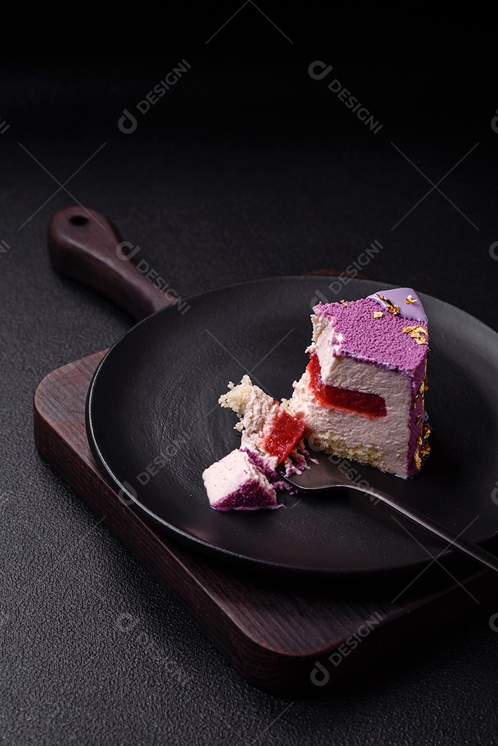 Delicioso bolo de mousse doce fresco com recheio de frutas vermelhas coberto com cobertura de veludo rosa sobre fundo escuro de concreto