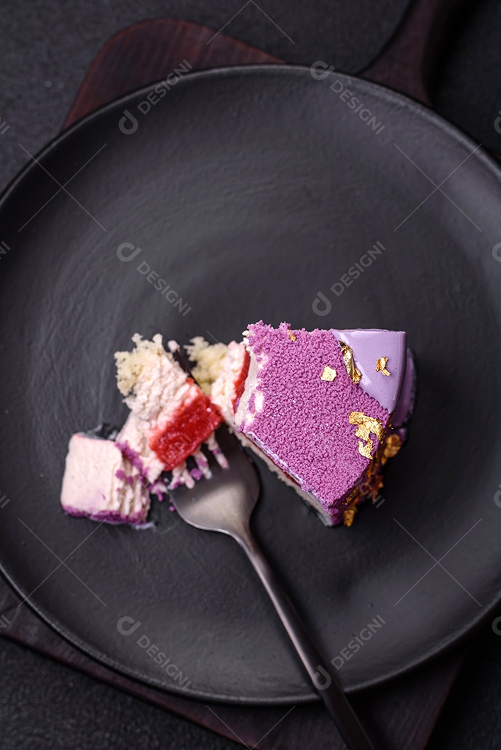 Delicioso bolo de mousse doce fresco com recheio de frutas vermelhas coberto com cobertura de veludo rosa sobre fundo escuro de concreto