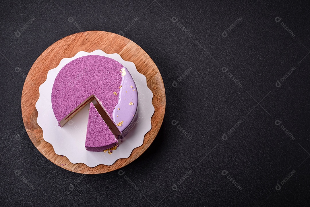 Delicioso bolo de mousse doce fresco com recheio de frutas vermelhas coberto com cobertura de veludo rosa sobre fundo escuro de concreto