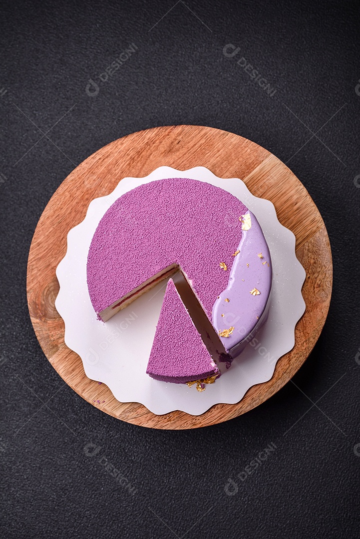 Delicioso bolo de mousse doce fresco com recheio de frutas vermelhas coberto com cobertura de veludo rosa sobre fundo escuro de concreto